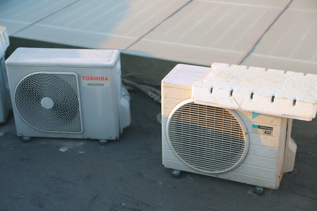 a-couple-of-air-conditioners-sitting-next-to-each-other-lnhhsnu1nza